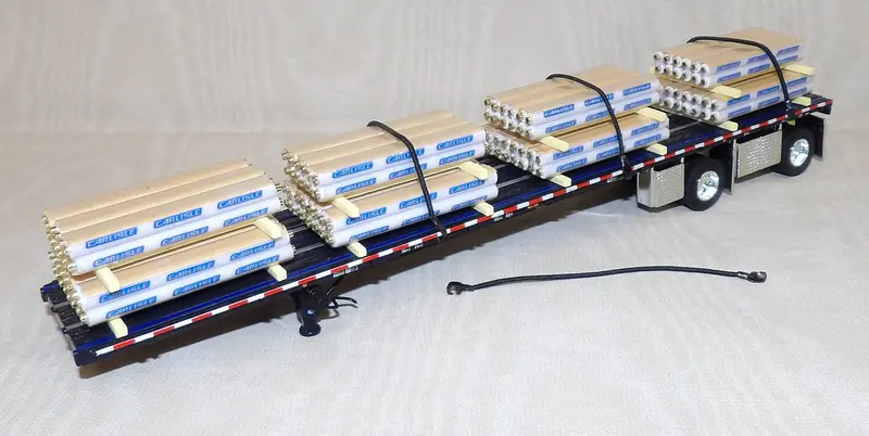 Wilson 53′ Roadbrute Flatbed Trailer with Shrink-Wrapped Paper Tube Load – 1:64 Scale